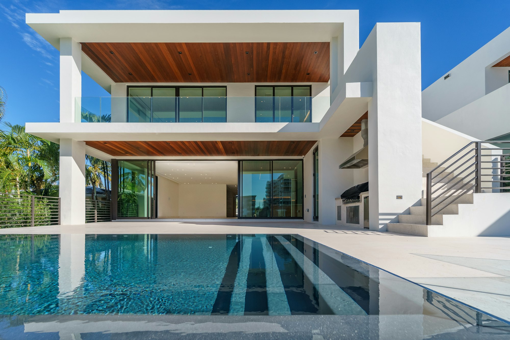 Modern Boca style home with a pool and tropical landscaping